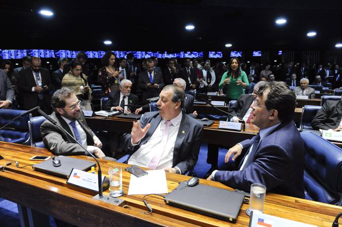 Plínio Valério, Omar Aziz e Eduardo Braga conversam no plenário do Senado em fotografia de arquivo.