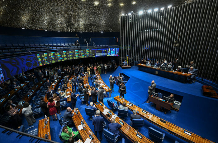 Vista do plenário do Senado Federal durante sessão, com parlamentares e a Mesa ao fundo.