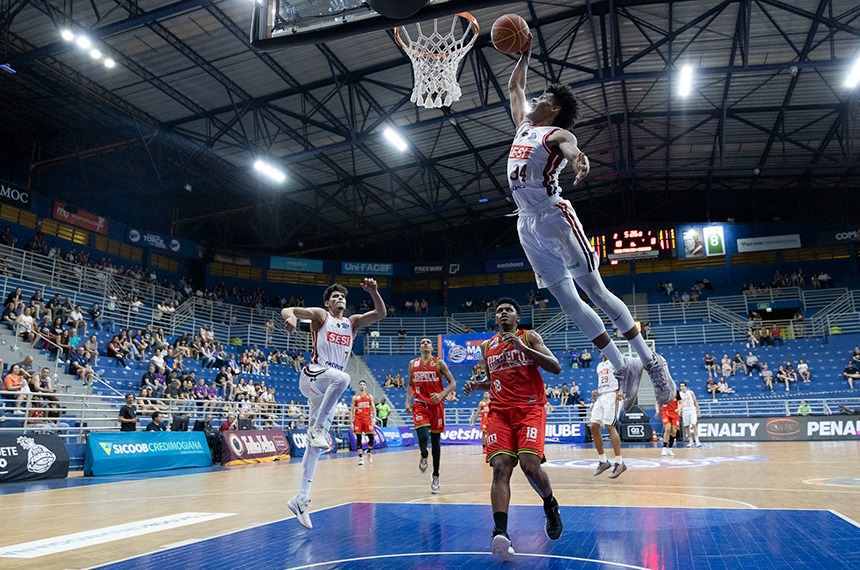 Jogador de basquete de Franca próximo à cesta durante partida no ginásio Pedrocão.