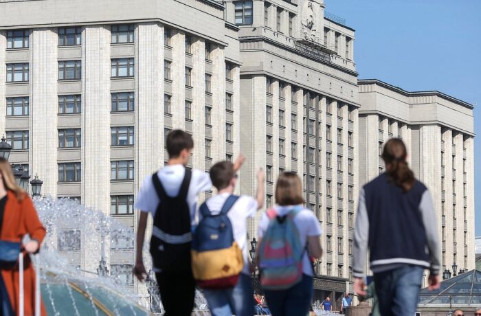 Pedestres diante do edifício da Duma Estatal, em Moscou.