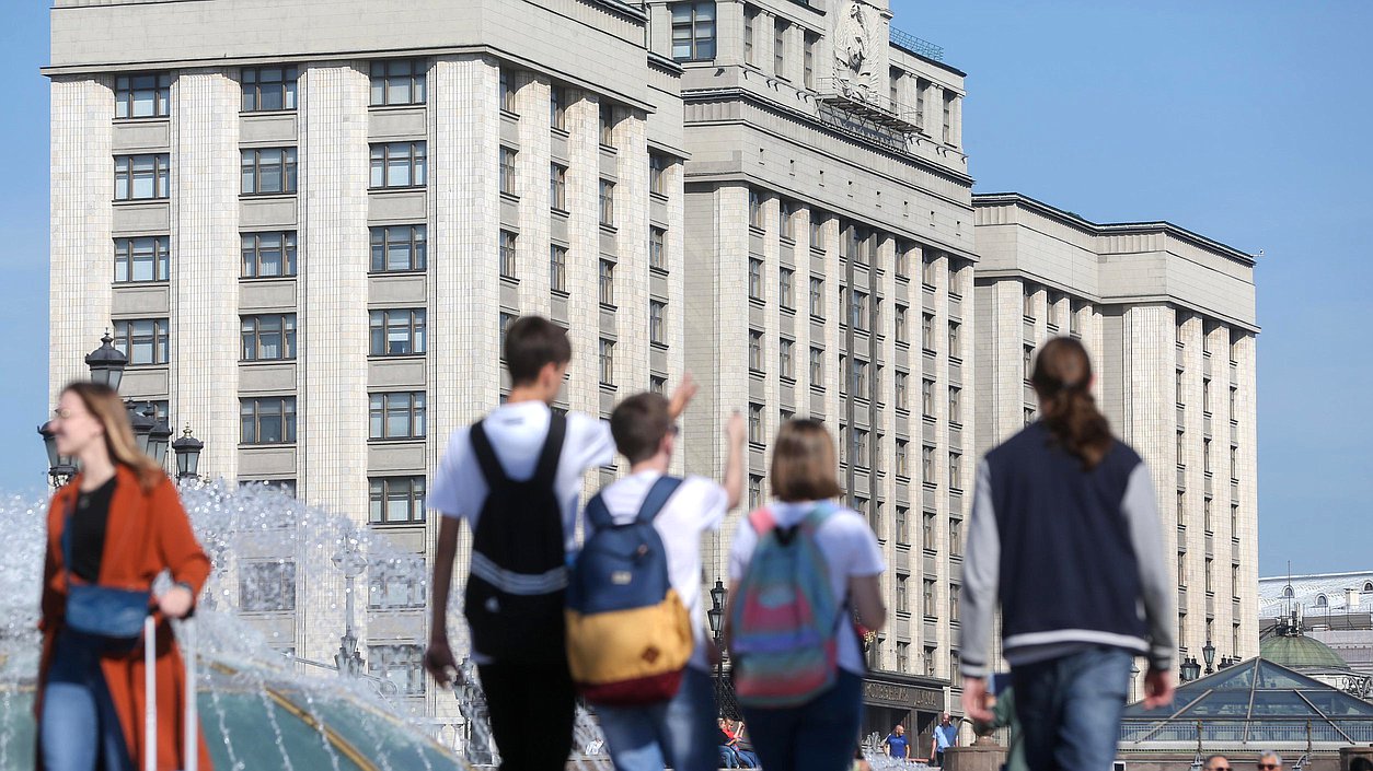 Pedestres diante do edifício da Duma Estatal, em Moscou.