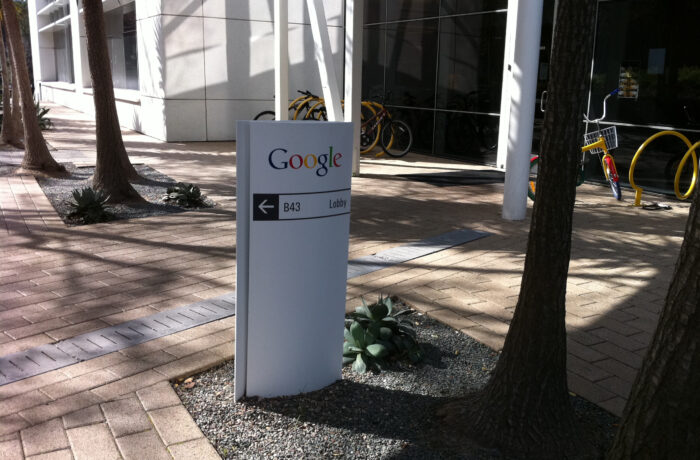 Fachada de um edifício do campus do Google em Mountain View, com placa da empresa.